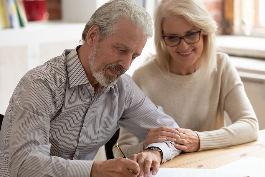 Happy Older Family Couple Husband And Wife Sign Legal Paper